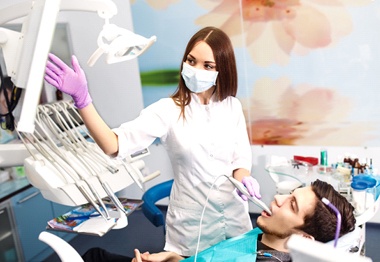 A dentist examining a patients smile with an intraoral camera.