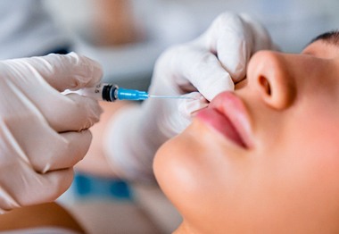 A dentist prepares to inject Botox in Hoboken into a patient’s face