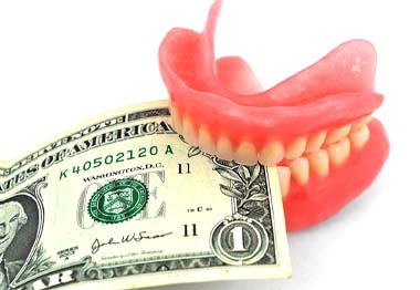 Model of a denture biting into a dollar bill