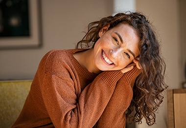 Smiling woman with a sweater sitting down