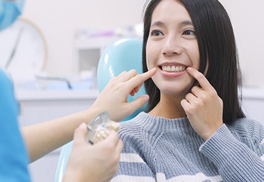 Woman smiling during dental implant consultation 