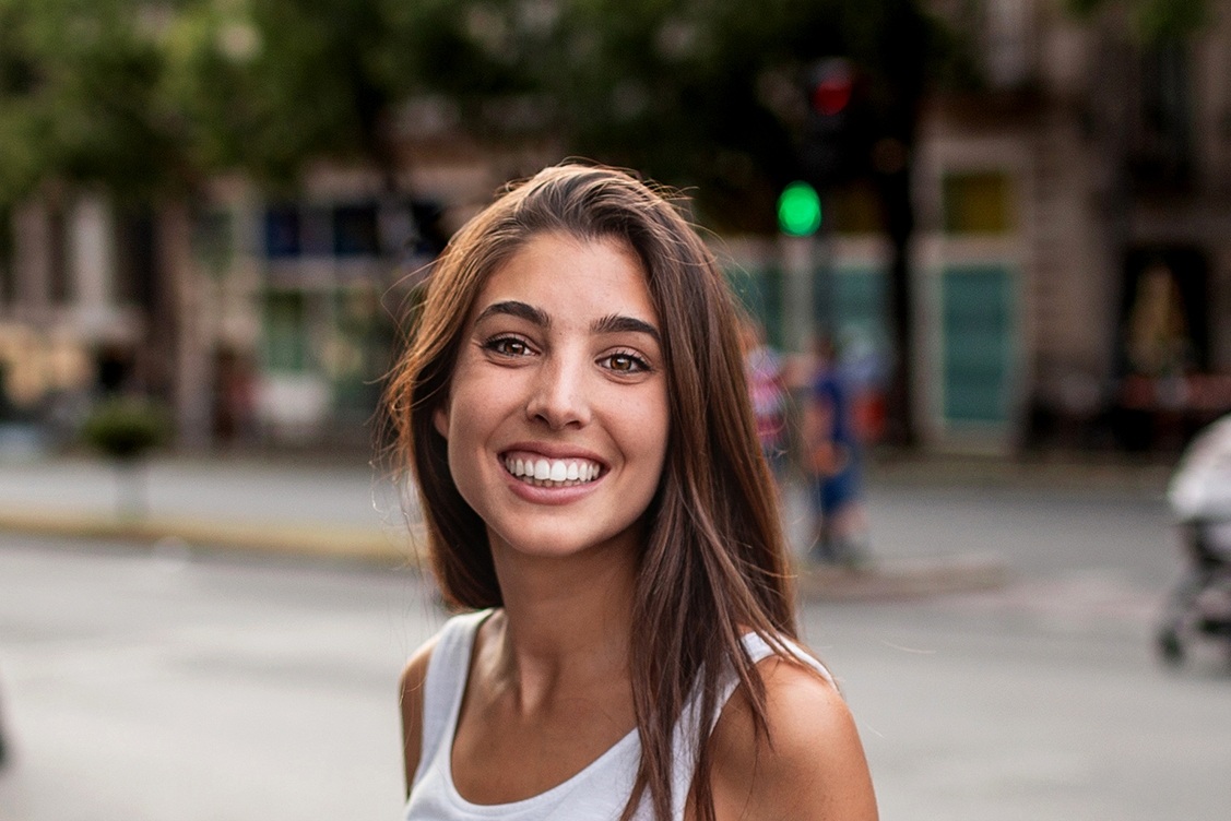 Young woman smiling outdoors on a city street