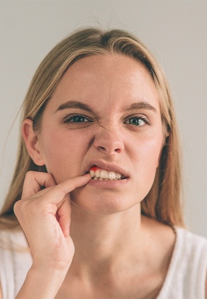 Woman looking at red inflamed gums before periodontal therapy