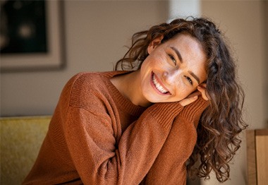 a woman smiling after following dental implant post-op instructions