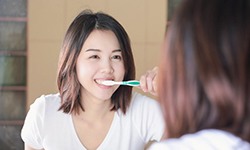 woman brushing her teeth 