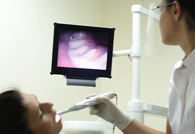 Dentist and patient looking at intraoral images on computer screen